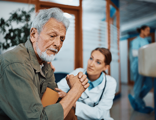 A doctor attentively consulting an elderly man in a medical setting.